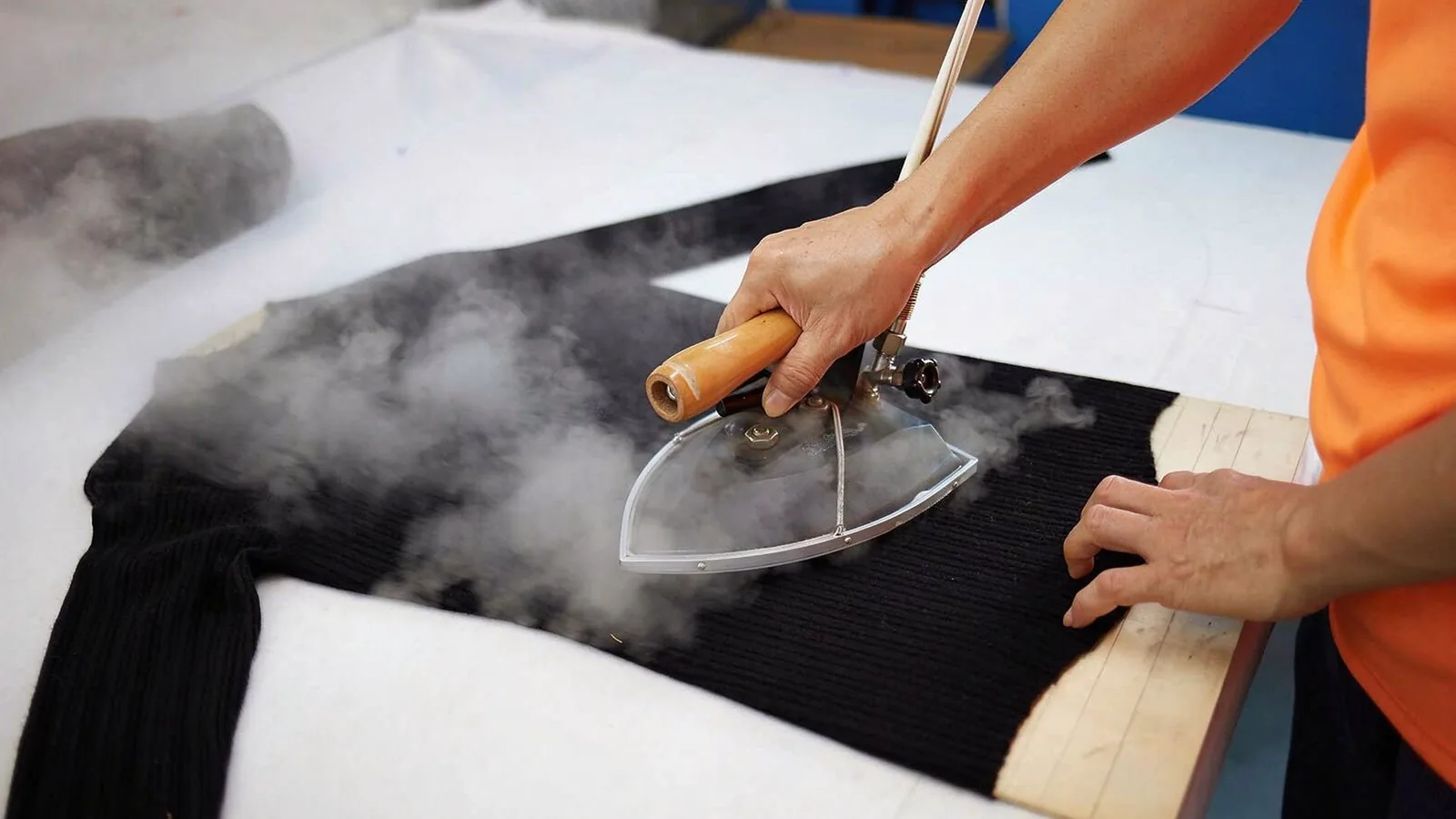 Steam pressing a knitted garment on the factory line